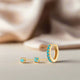 A set of gold and turquoise earrings, including different styles such as huggie and studs, displayed against a neutral background.