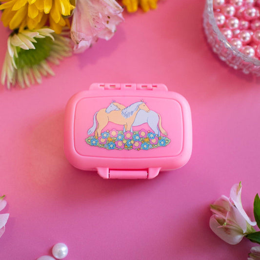 Pink container with a horse design on a pink background with flowers and pearls