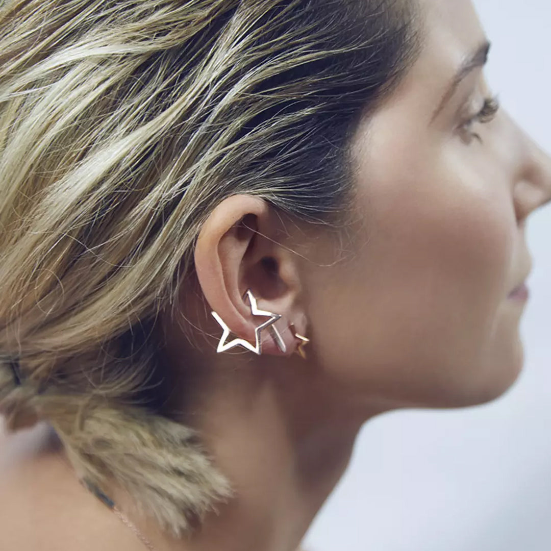 Close-up of a woman wearing star-shaped earrings with a blurred background