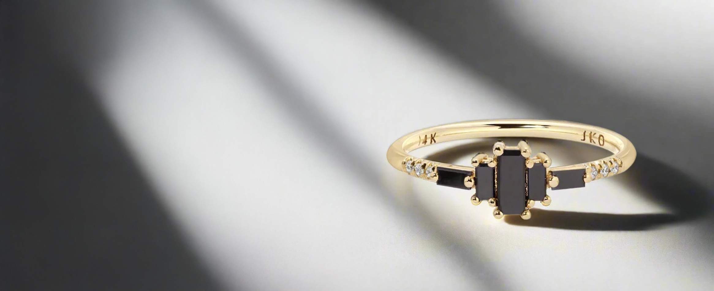 Jennie Kwon Black Diamond Mercato Ring on a plain table top with strong shadows