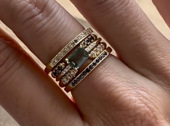 Black diamond rings by Jennie Kwon, stacked with a green sapphire ring