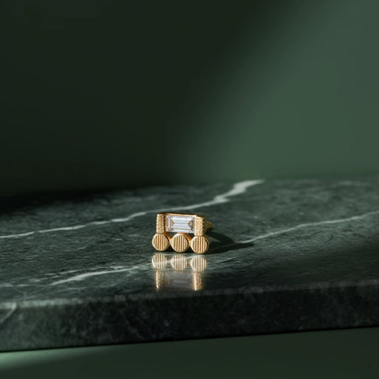 Jennie Kwon Baguette 3 Dot Stud Single Earring on green marble and green background