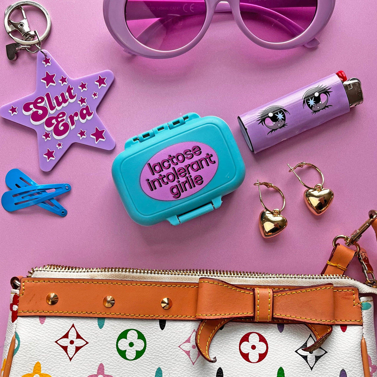 Colorful handbag with various accessories on a pink background