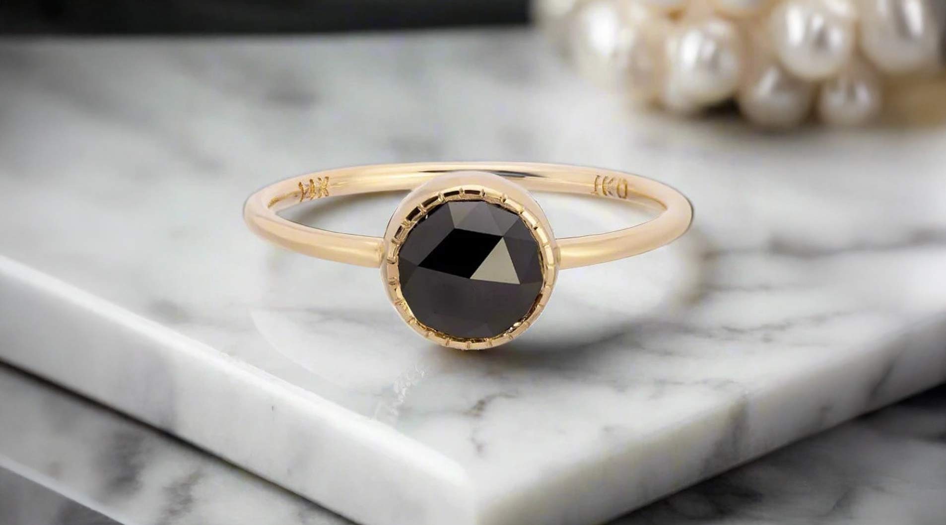 Jennie Kwon Black Diamond Largo Ring on a white marble table top