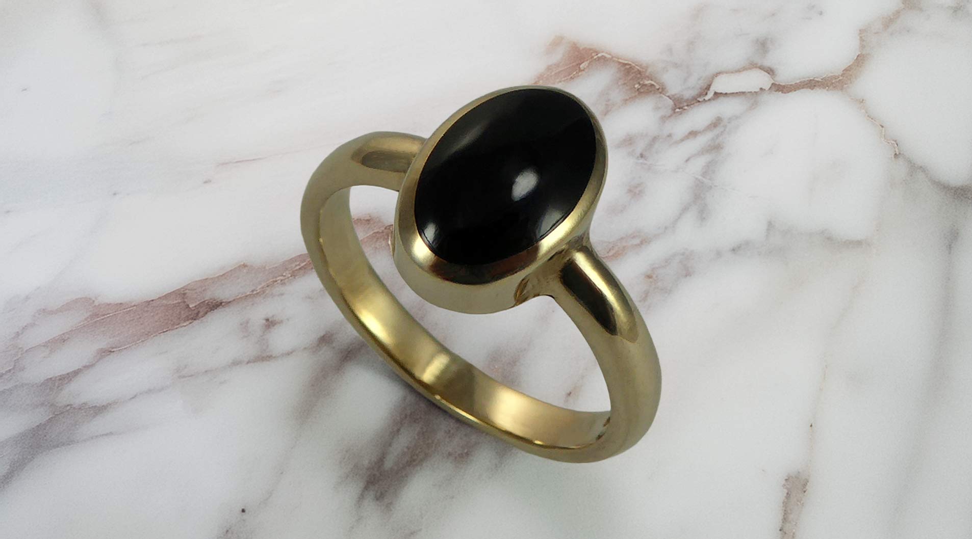 Black onyx ring on a white marble table top